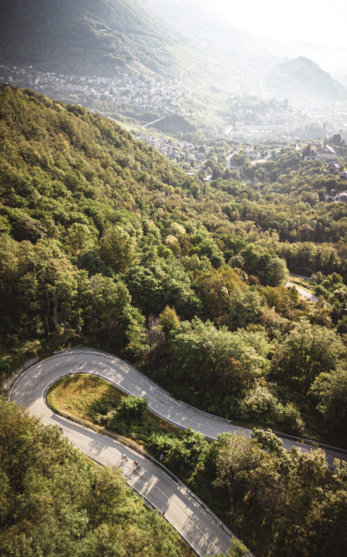 STRADA DEL VINO IN ROAD-BIKE Gravellina Vista Panoramica dei Monti Valtellinesi con i Ciclisti che pedalano nella Strada del Vino